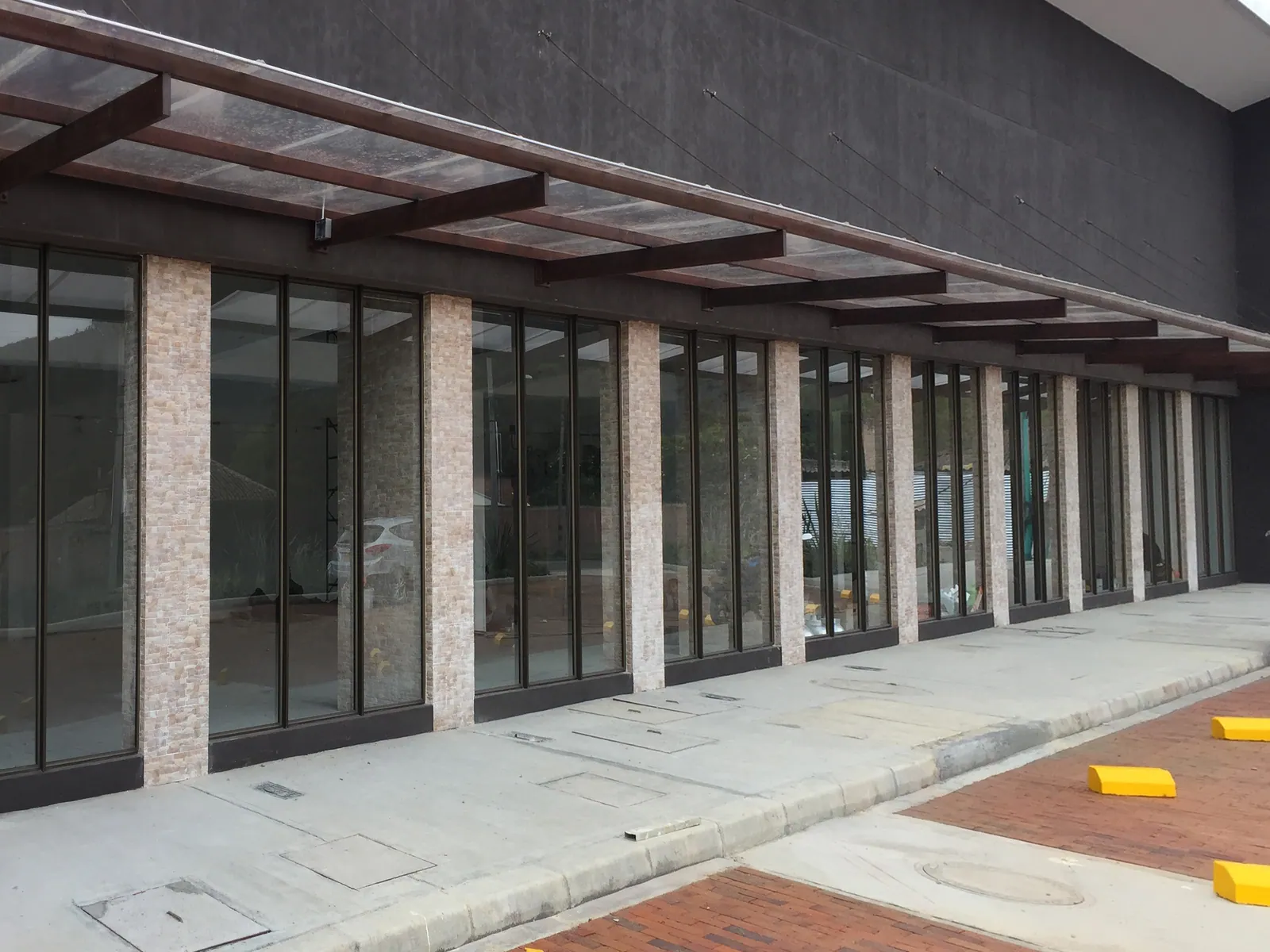 Park Place: Vitrinas y puertas de acceso para un conjunto de locales comerciales, con modulación repetida a lo largo de toda la fachada.